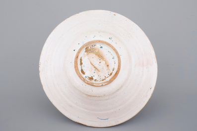 A large Spanish blue and white faience bowl with a sun face, 19th C.